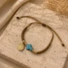 ChatGPT Image Jul 1, 2026, 03_59_45 PM Handmade Tan String Bracelet with Aqua Cross